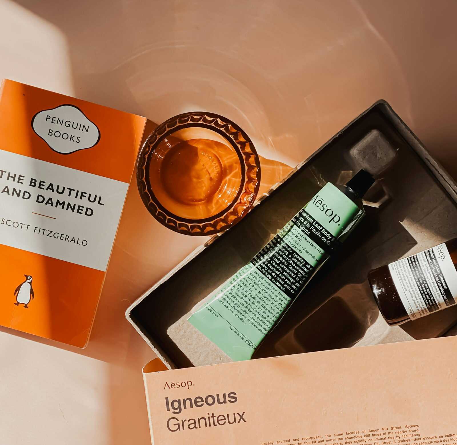 Flat lay featuring Aesop products with a copy of 'The Beautiful and Damned'.